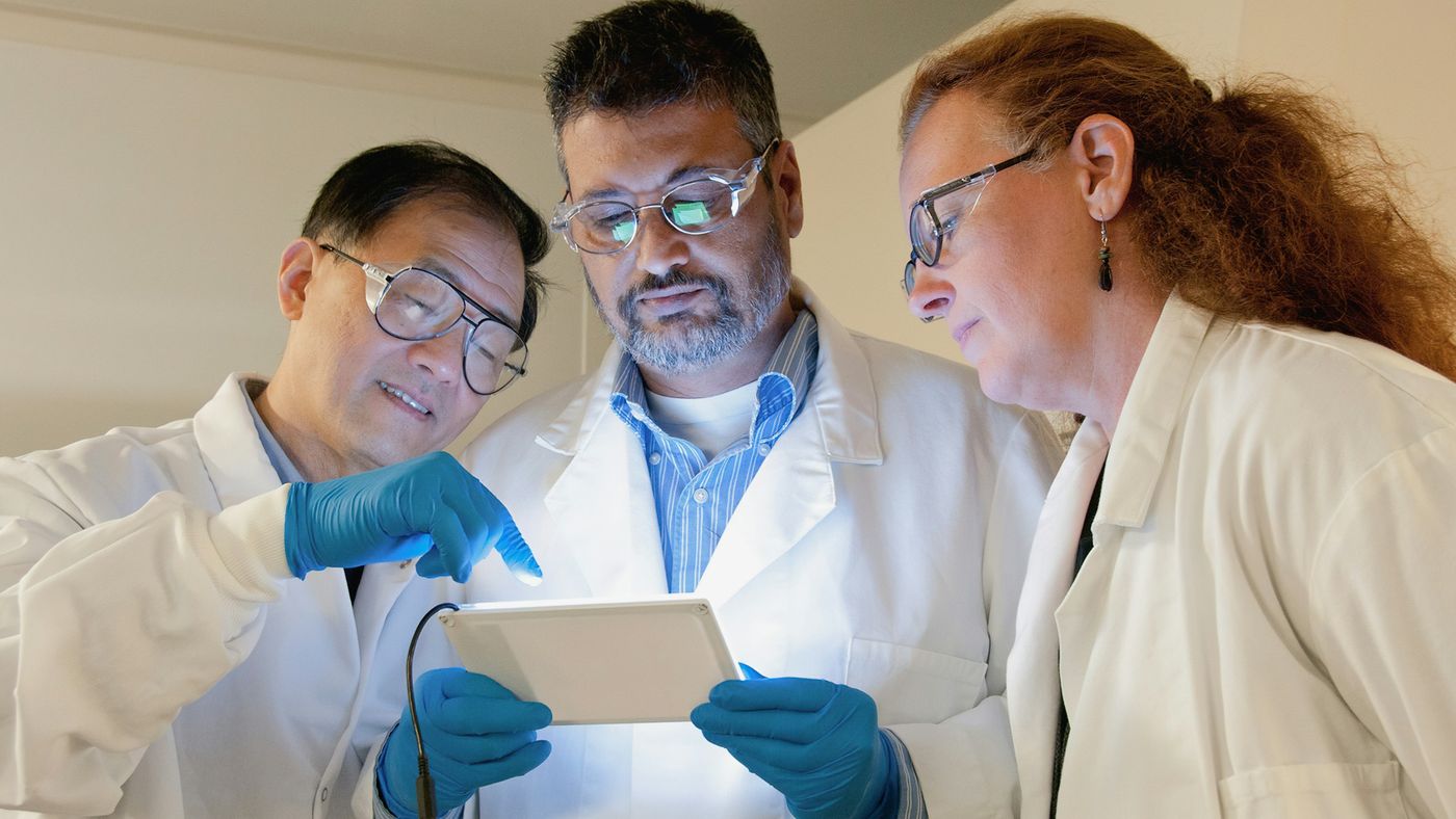 Three professionals discussing documents together